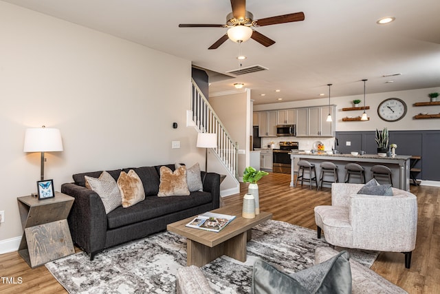 living room featuring ceiling fan and light wood-type flooring