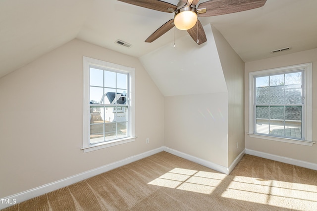 additional living space featuring ceiling fan, light carpet, and vaulted ceiling