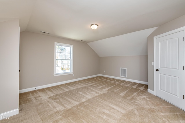 bonus room featuring lofted ceiling and light carpet