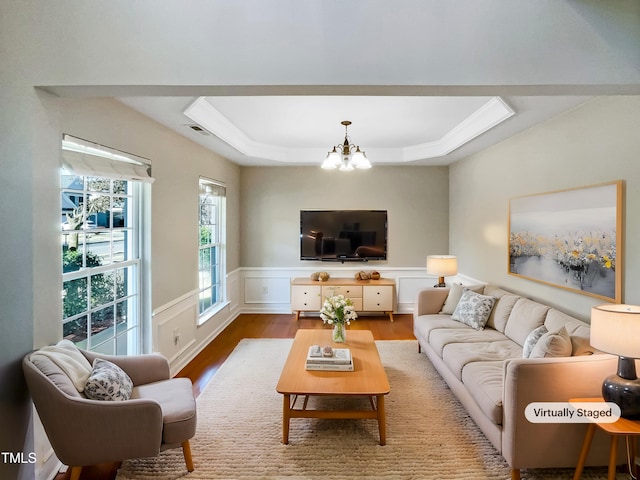 1012 Fulbright Dr, Morrisville, NC 27560 - living area with a chandelier, a tray ceiling, wood finished floors, and wainscoting