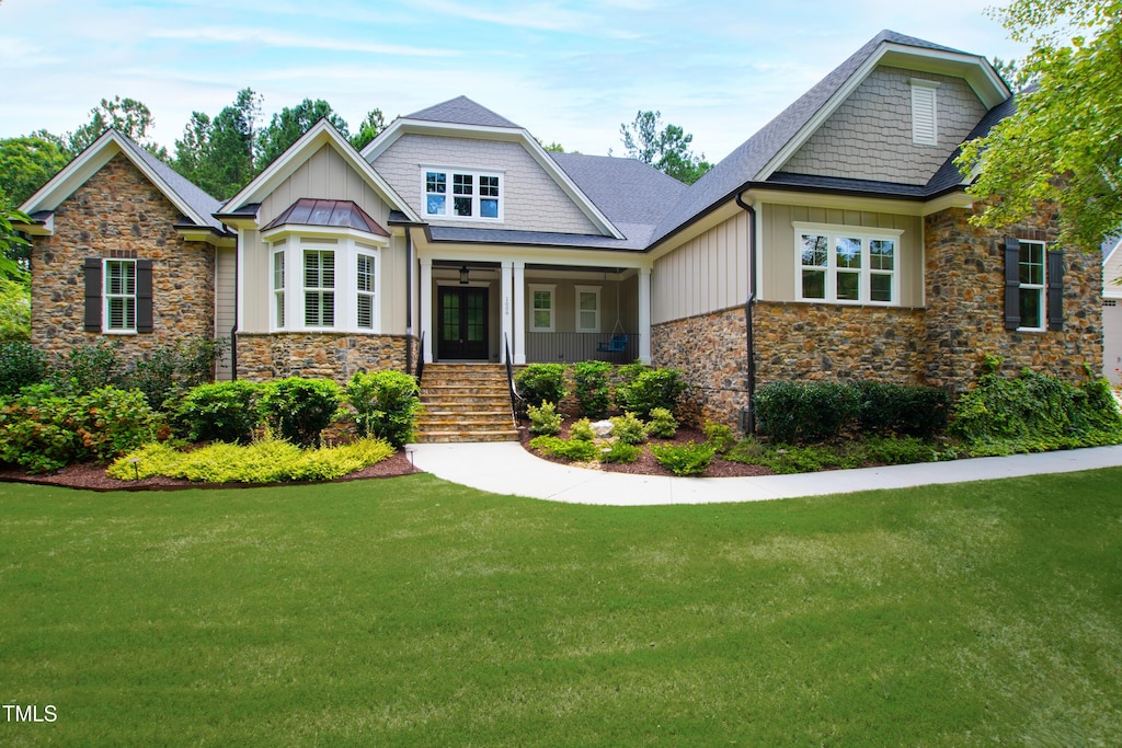 craftsman-style home featuring a porch and a front lawn