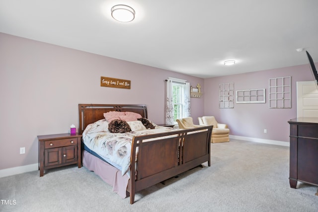 bedroom with baseboards and light colored carpet