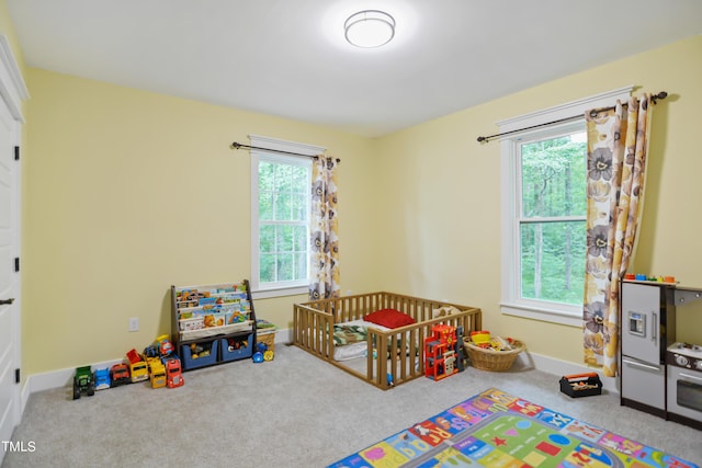 bedroom with carpet, a nursery area, and baseboards