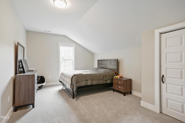 bedroom featuring visible vents, baseboards, vaulted ceiling, and light colored carpet