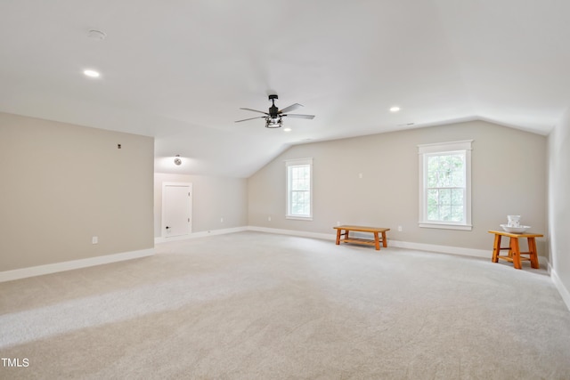 bonus room with light carpet, lofted ceiling, a ceiling fan, and baseboards