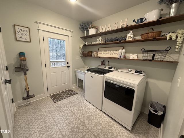 laundry area with laundry area, light tile patterned floors, baseboards, independent washer and dryer, and a sink