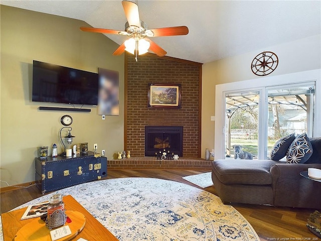 living room with dark hardwood / wood-style flooring, ceiling fan, a fireplace, and lofted ceiling