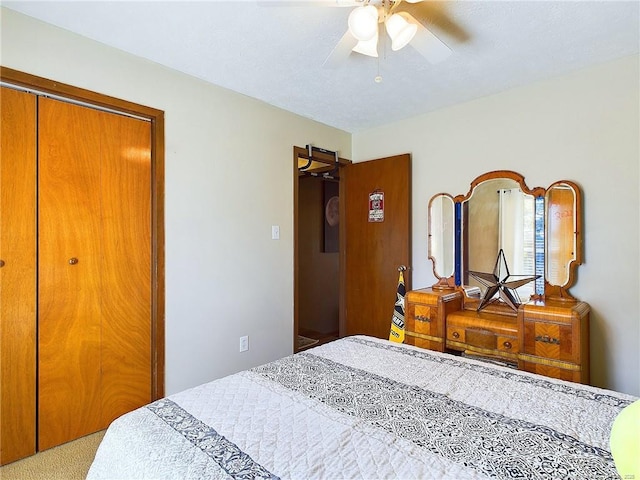 carpeted bedroom featuring ceiling fan and a closet