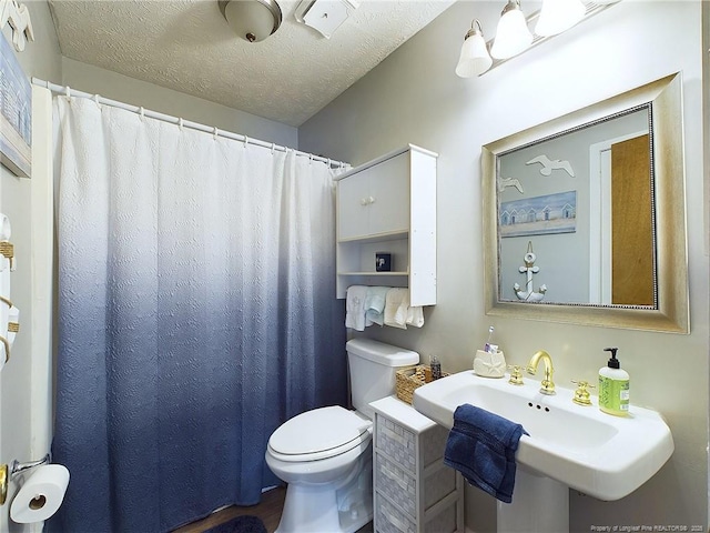 bathroom featuring sink, toilet, and a textured ceiling