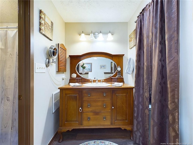 bathroom featuring hardwood / wood-style flooring, vanity, and a textured ceiling