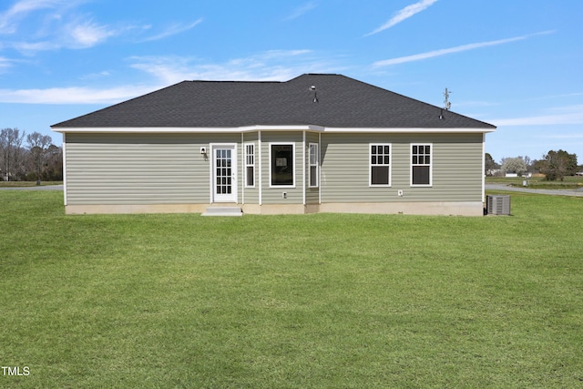 rear view of property featuring central AC and a yard