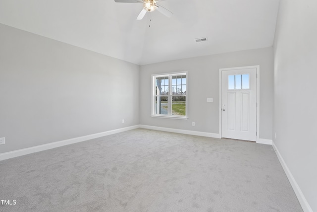 carpeted entrance foyer featuring visible vents, baseboards, lofted ceiling, and ceiling fan