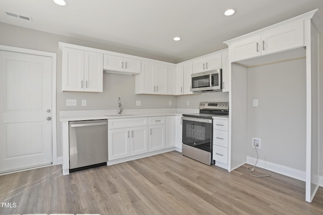 kitchen featuring a sink, visible vents, appliances with stainless steel finishes, and white cabinets