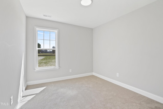 carpeted spare room with visible vents and baseboards