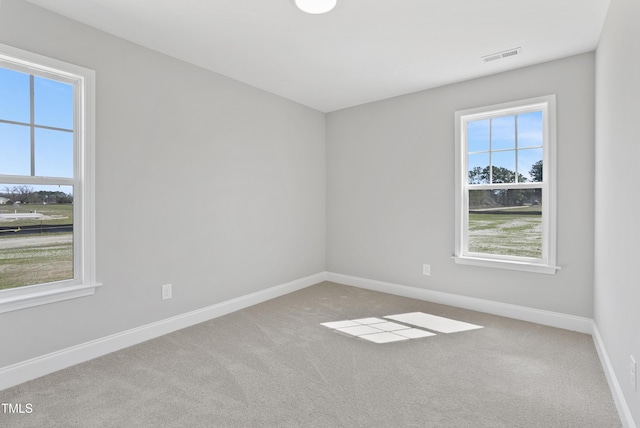 empty room with visible vents, carpet flooring, and baseboards