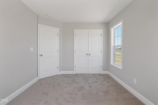 unfurnished bedroom with a closet, baseboards, and carpet floors