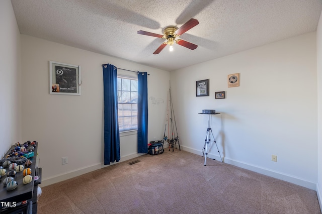 interior space with ceiling fan, carpet floors, and a textured ceiling