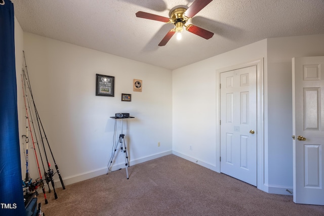 unfurnished bedroom featuring light carpet, a textured ceiling, and ceiling fan