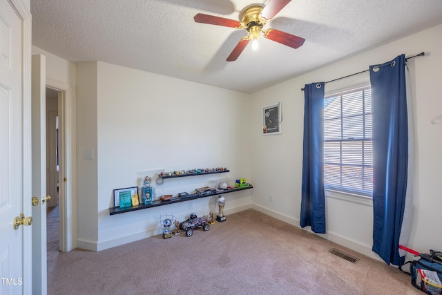 miscellaneous room featuring light carpet, a textured ceiling, and ceiling fan