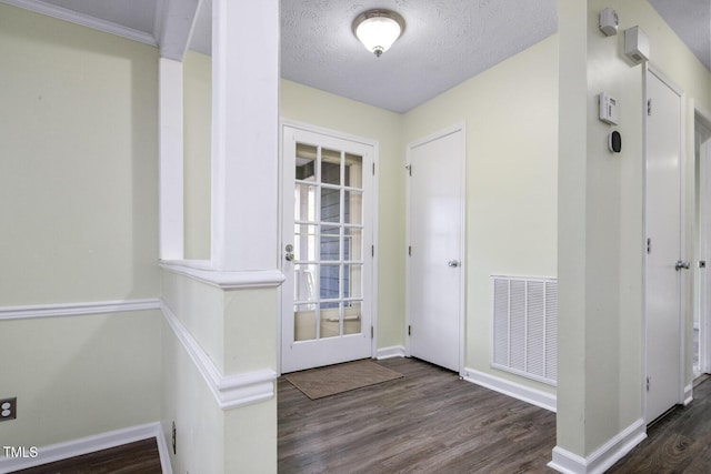 foyer featuring dark wood-type flooring and a textured ceiling