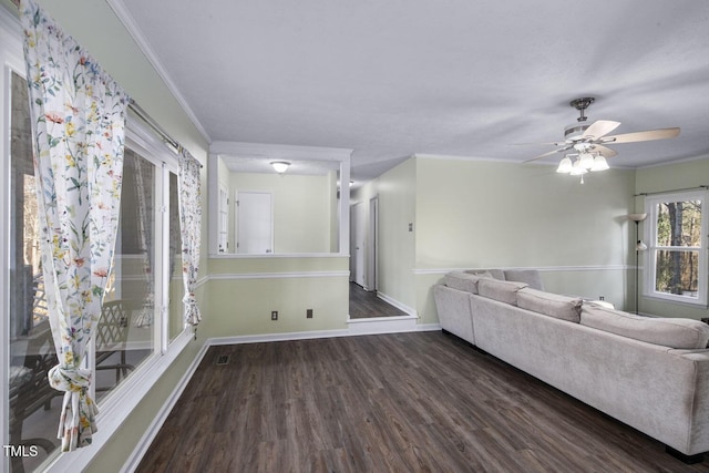 unfurnished living room featuring crown molding, ceiling fan, and dark wood-type flooring