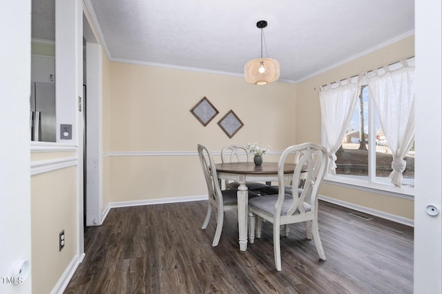 dining space with dark hardwood / wood-style floors and crown molding