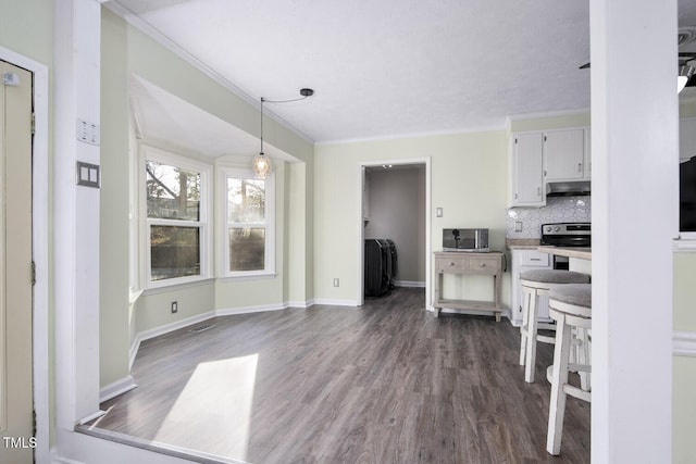 kitchen featuring appliances with stainless steel finishes, backsplash, dark wood-type flooring, pendant lighting, and white cabinetry