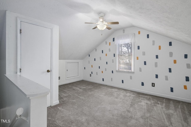 additional living space featuring a textured ceiling, ceiling fan, lofted ceiling, and light carpet