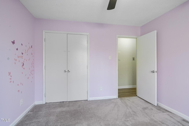 unfurnished bedroom with light carpet, a closet, and ceiling fan