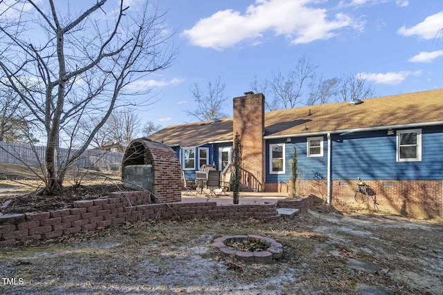 rear view of property with a fire pit and a patio