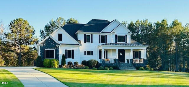 view of front of home with a porch and a front lawn