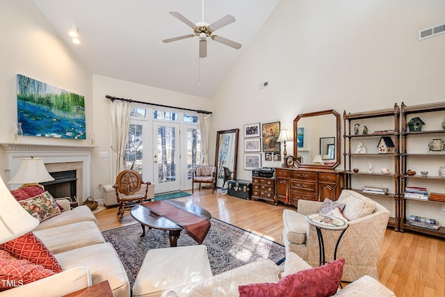 living room with ceiling fan, light hardwood / wood-style floors, and high vaulted ceiling