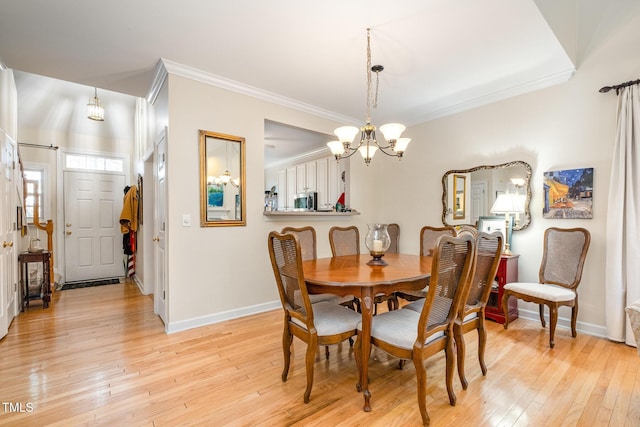 dining room with crown molding, light hardwood / wood-style floors, and a notable chandelier