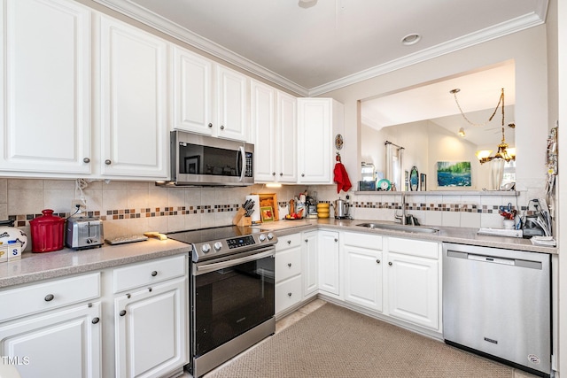 kitchen with white cabinets, appliances with stainless steel finishes, a chandelier, and sink