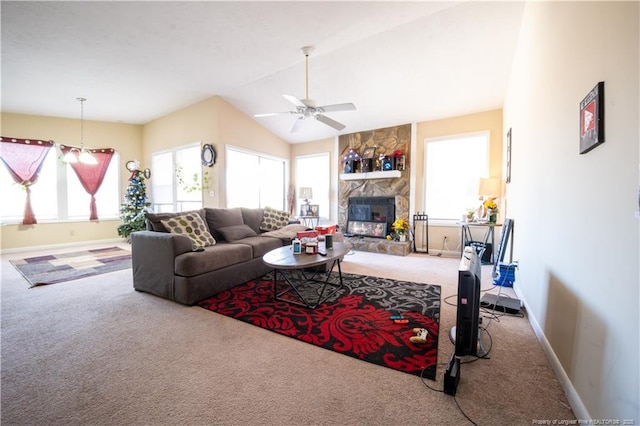 carpeted living room featuring a stone fireplace and ceiling fan