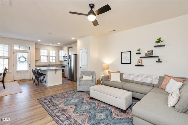 living room featuring ceiling fan and wood-type flooring