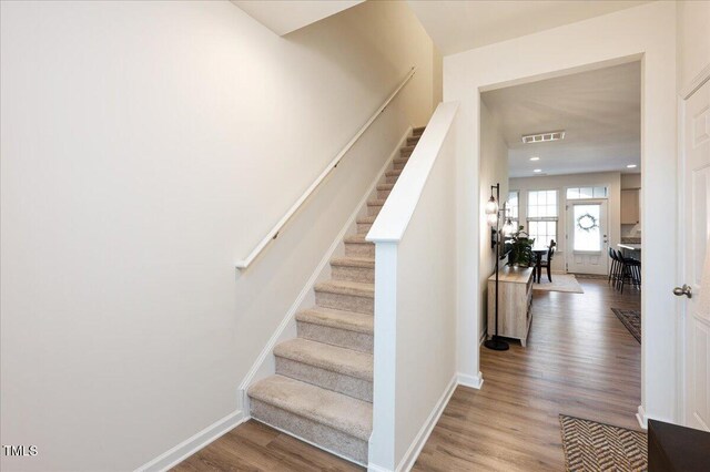 stairs with hardwood / wood-style flooring