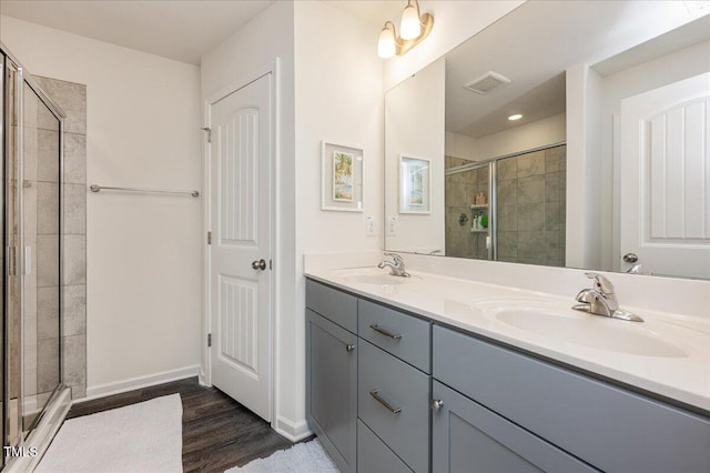 bathroom featuring a shower with shower door, hardwood / wood-style floors, and vanity