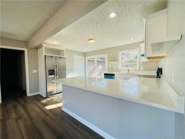 kitchen with kitchen peninsula, appliances with stainless steel finishes, light stone counters, a textured ceiling, and white cabinets