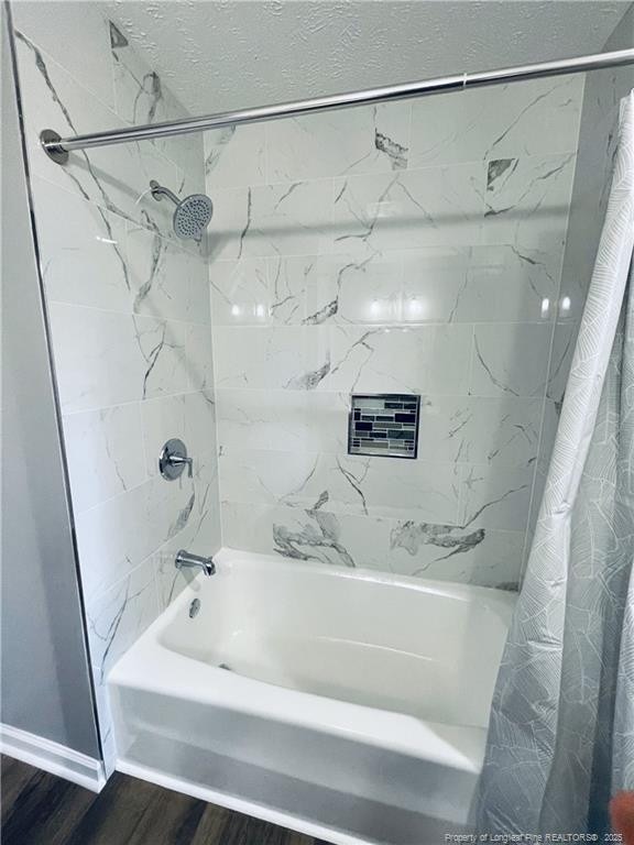 bathroom featuring wood-type flooring and shower / tub combo