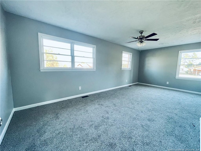 spare room featuring a textured ceiling, carpet floors, and ceiling fan