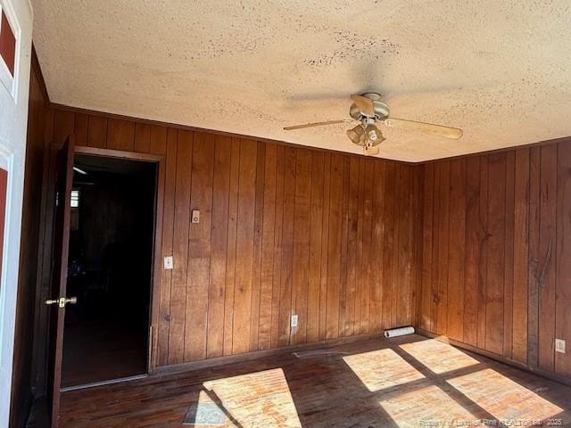 spare room with wood walls and a textured ceiling