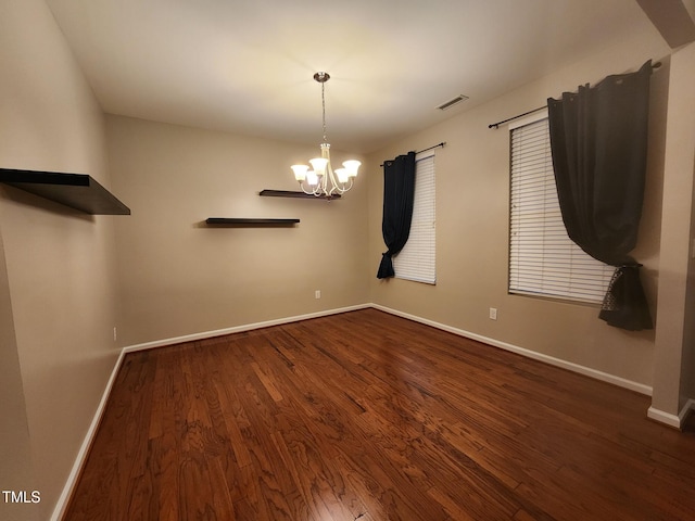 unfurnished dining area with a chandelier and dark hardwood / wood-style floors