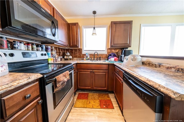 kitchen featuring backsplash, ornamental molding, stainless steel appliances, sink, and pendant lighting