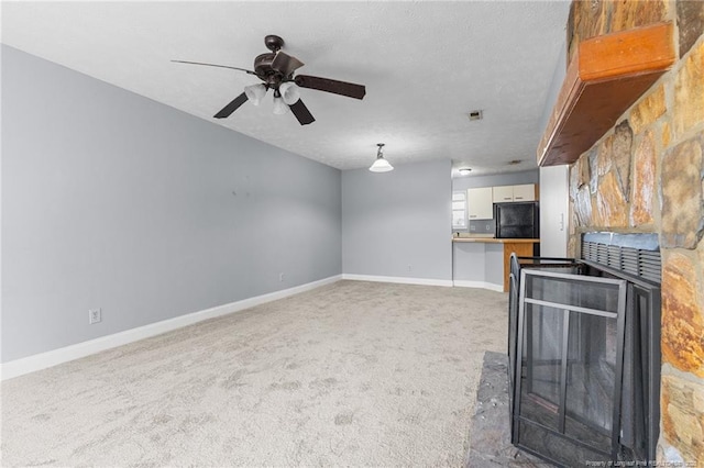 unfurnished living room with a textured ceiling, carpet floors, and ceiling fan