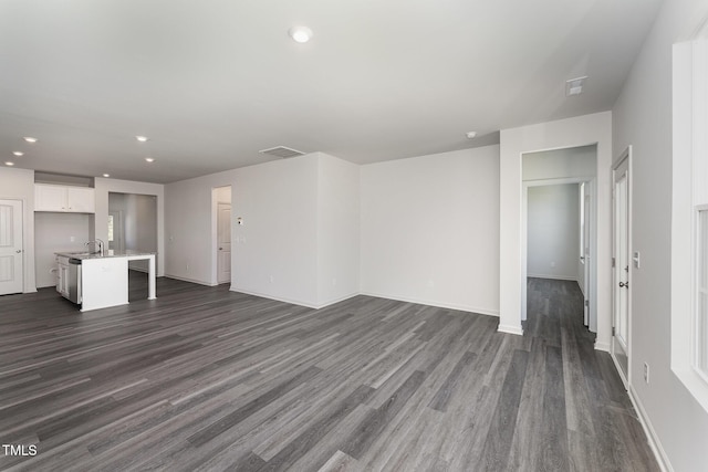 unfurnished living room with sink and dark wood-type flooring