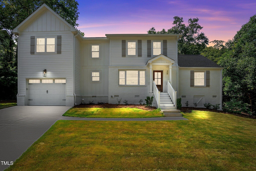 view of front of home featuring a lawn and a garage