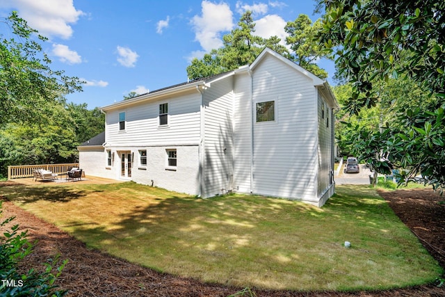 rear view of house with a yard and a patio