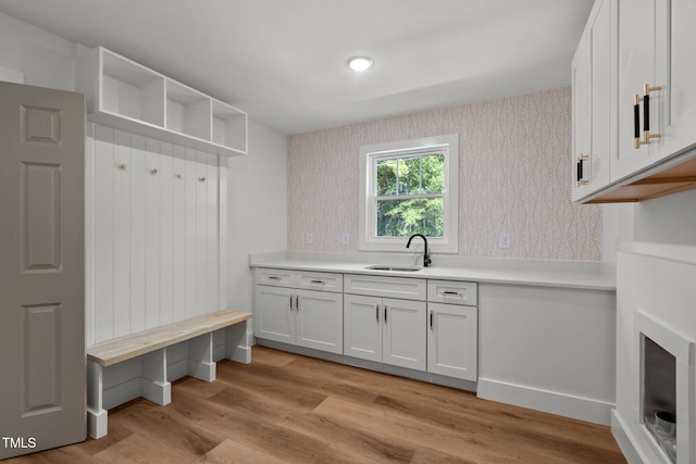 mudroom with sink and light hardwood / wood-style flooring