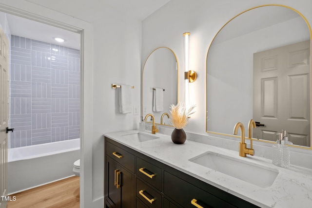 full bathroom featuring wood-type flooring, vanity, toilet, and tiled shower / bath